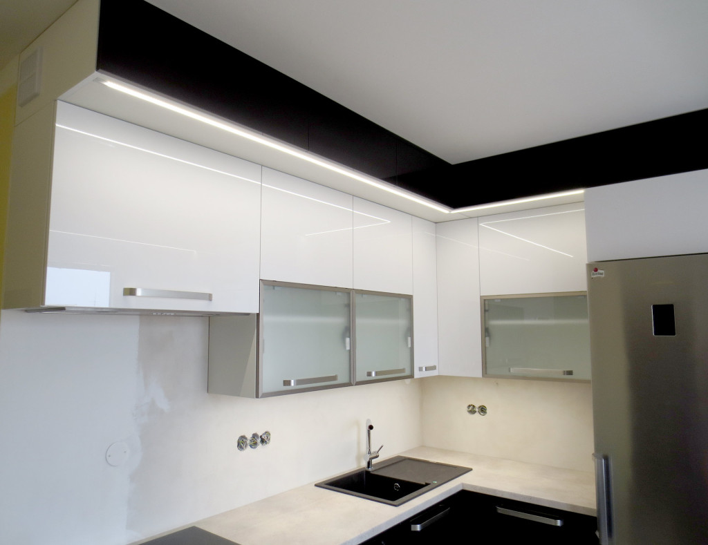 Černo-bílá kuchyň s hlubokými skříňkami pod stropem